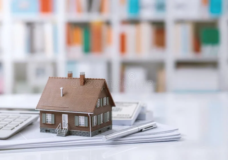 A model home on a desk with planning documents